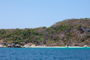blue sea with white sand on the background of the jungle and rocks. Thailand Racha Island