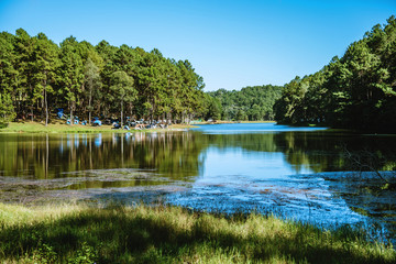 Obraz premium Beautiful natural landscape with fog floating on the lake surface in the sunrise at Pang-ung.