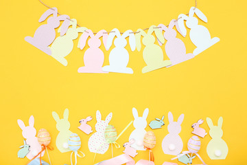 Easter rabbits with eggs on yellow background