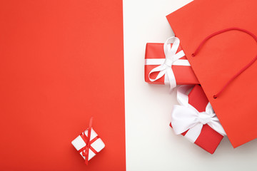 Shopping bag with gift boxes on colorful background