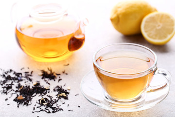 Cup of tea with dry leafs and teapot