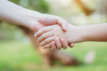 Close up at the hands two teenage girls. Show unity as a collaborative work together. To succeed, one has to understand each other in communication. Concept International Women's Day