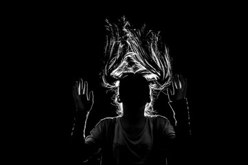 art picture of a scary girl jumping in flight with her hair down to her sides in contrasting light...