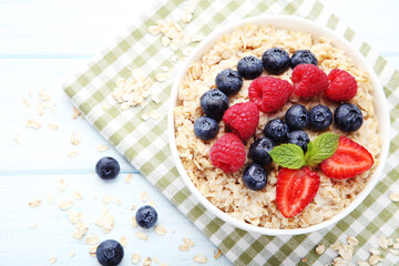 Oatmeal with berries in bowl on wooden table