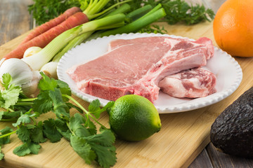 Ingredients for roasted pork chops and vegetables with avocado orange salsa
