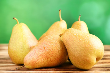 Ripe pears with water drops on brown wooden table