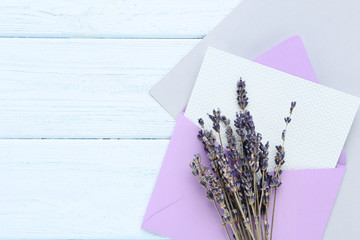Blank paper with envelope and lavender flowers on wooden table