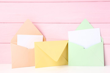 Colorful paper envelopes on wooden background