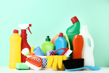 Bottles with detergent and cleaning tools on wooden table