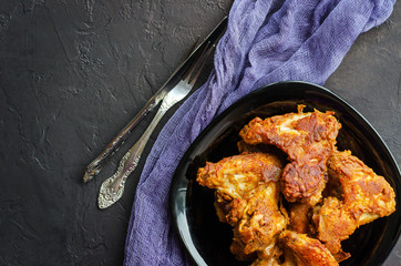 Spicy Deep Fried Breaded Chicken Wings on dark stone background.