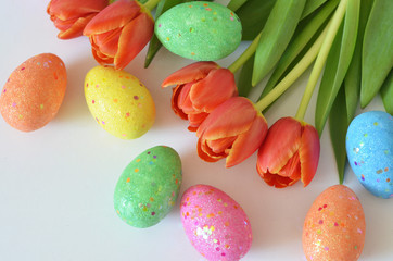 Happy Easter. Congratulatory easter background. Easter eggs and flowers tulip on white background.