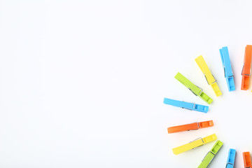 Colorful plastic clothespins on white background