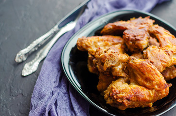 Spicy Deep Fried Breaded Chicken Wings on dark stone background.