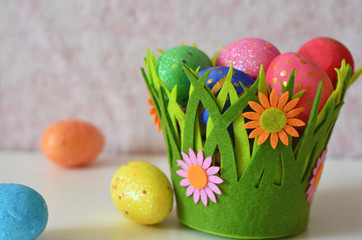 Happy Easter Day. Easter eggs concept. Closeup Colorful Easter eggs in nest and basket green crass on white wooden background.