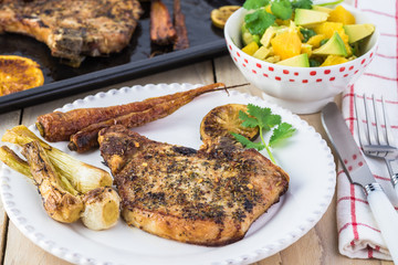 Roasted pork chops and vegetables with avocado orange salsa