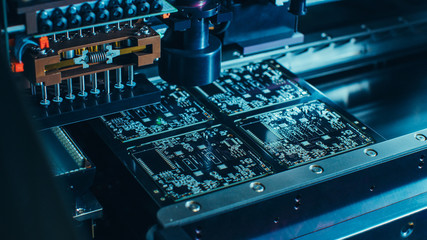 Macro Close-up Shot of Printed Circuit Board on a Factory Assembly Line with Automated Robotic Arm...