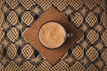 Flat lay with black background with coffee mug and donut with  lace