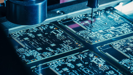 Factory Machinery at Work: Printed Circuit Board Being Assembled with Automated Robotic Arm, Pick...
