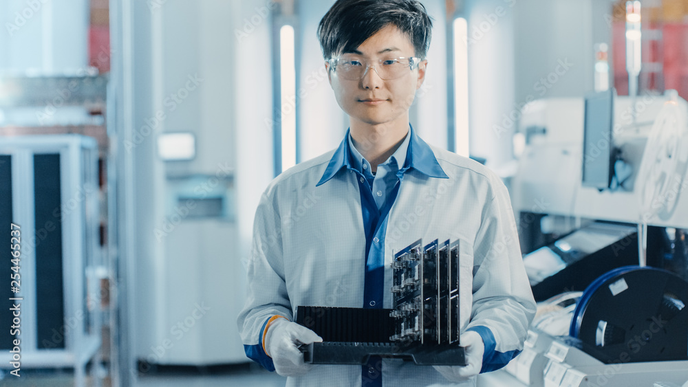Poster on high-tech factory asian worker holds batch with electronic printed circuit board assembled with u
