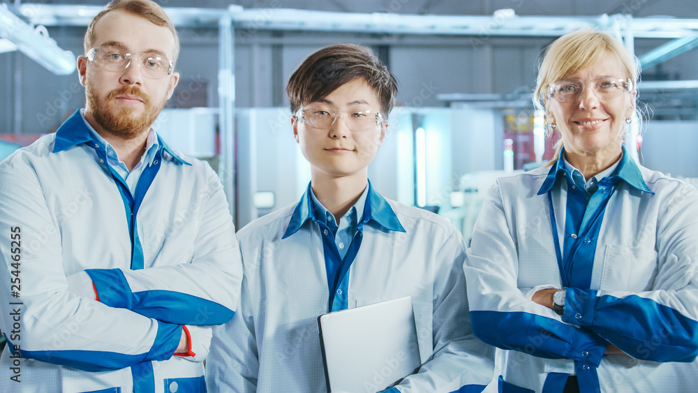 Aufkleber on high-tech factory: portrait of three professional engineers. in the background electronic printed