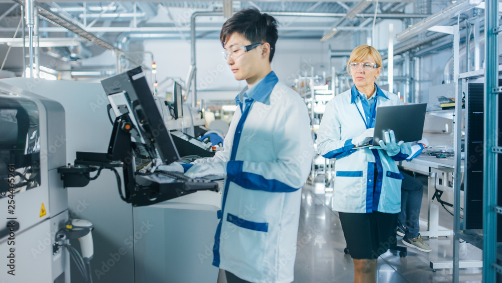 Poster on high tech factory asian engineer uses computer for programing pick and place electronic machinery