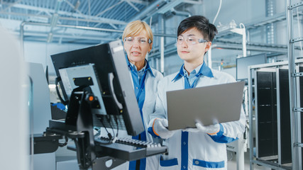 On High-Tech Factory Asian Engineer Talks with Female Supervisor, Use Computer for Programming Pick...