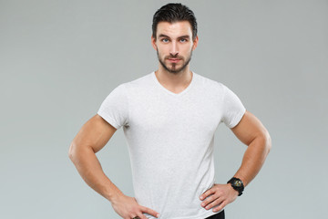 Attractive athletic man in a white shirt isolated on gray background.