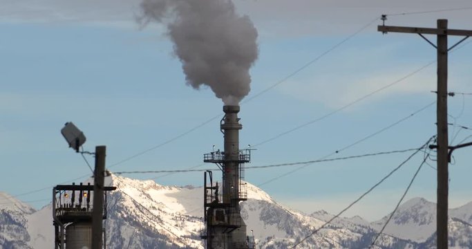 Zoomed in oil refinery steam coming out of tower