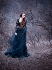 gorgeous attractive brunette, lady in a long black dress with bare open arms and shoulders, the...