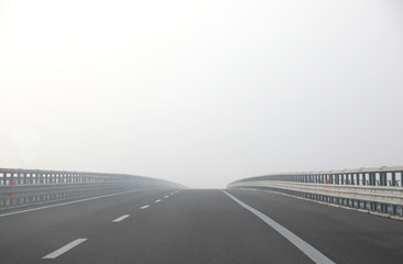 highway with dense dangerous fog without cars during a days in w
