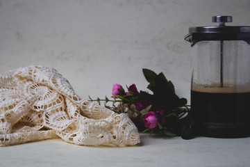 Marble background and pink flowers with coffee mug and donut lace and notepad 