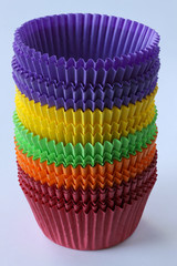 Stack of colorful empty paper forms capsules for muffins and cupcakes on white background - baking dessert - close up on white background