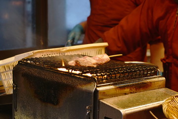 wagyu beef barbecue stabbing in wooden stick cooking on grilled stove street food at Hokkaido Japan