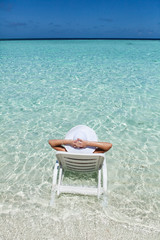 woman relaxing on deck chair on the beach