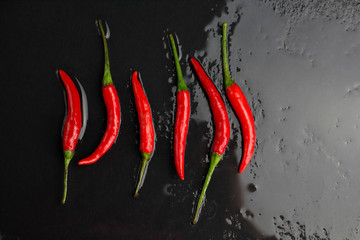 A lot of sharp hot spice red chilli cayenne pepper with wet drops of freshness water dew in line...