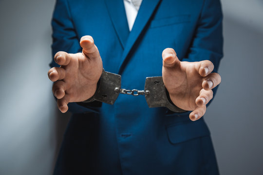 Young Man Hand Handcuffs On Dark Background