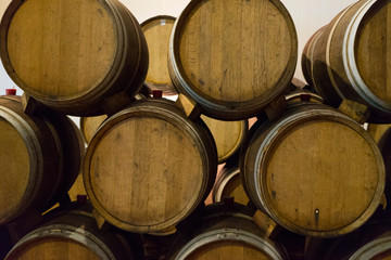 Wine barrels stacked in the old cellar of the winery. 