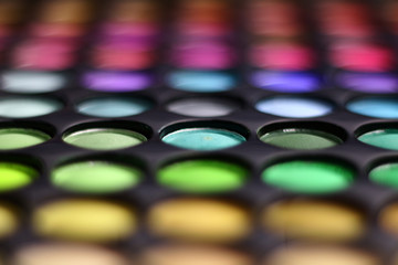 Different tonic green, light blue and purple make-up powder. 