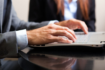 Male hands typing on a laptop keyboard