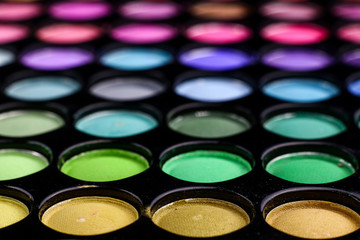 Different tonic green, light blue and purple make-up powder. 