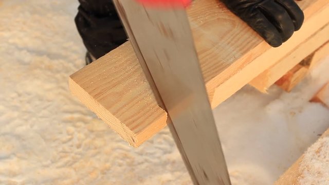 sawing the boards by hand saw