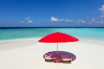 woman lying under red umbrella on the tropical beach