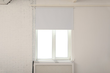 New modern window with roller blind in room