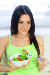 young woman eating fresh salad