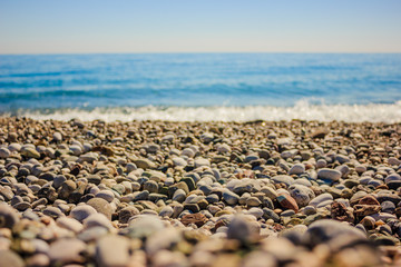Fototapeta na wymiar Mediterranean landscape in Antalya, Turkey. Blue sea, waves and pebble sandy beach