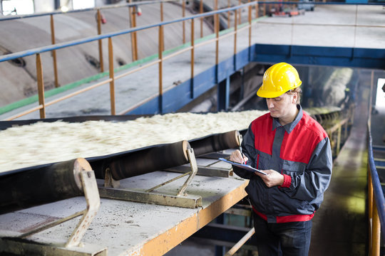 Transport of sugar on the production line, worker writes the quality information 