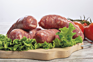 salsicce crude tre con insalata e pomodori fronte