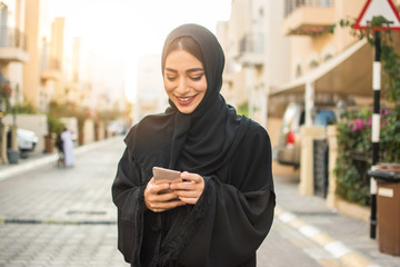 Portrait of a young arabian woman using mobile phone on the street