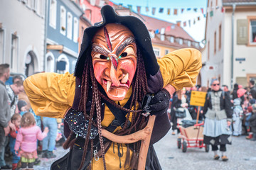 Evil witch with big teeth and long nose in black hat. Street carnival in southern Germany - Black Forest.
