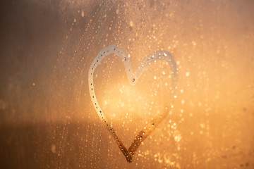 Abstract romantic background. Heart symbol on the misted glass